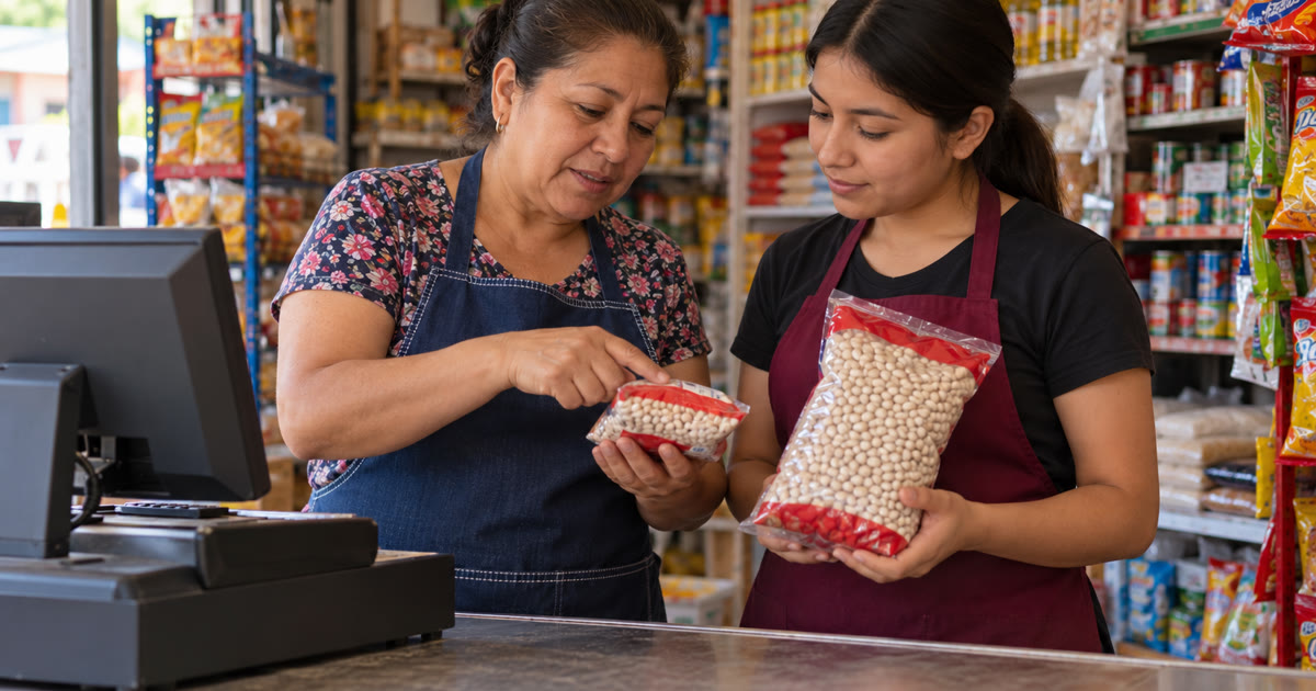 Dueña de una tienda de abarrotes enseñando a una cajera nueva a distinguir presentaciones de productos